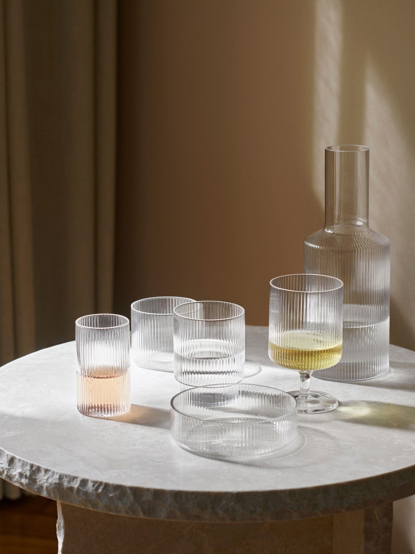 Ripple glasses, bowl, wine glass and carafe on a stone table