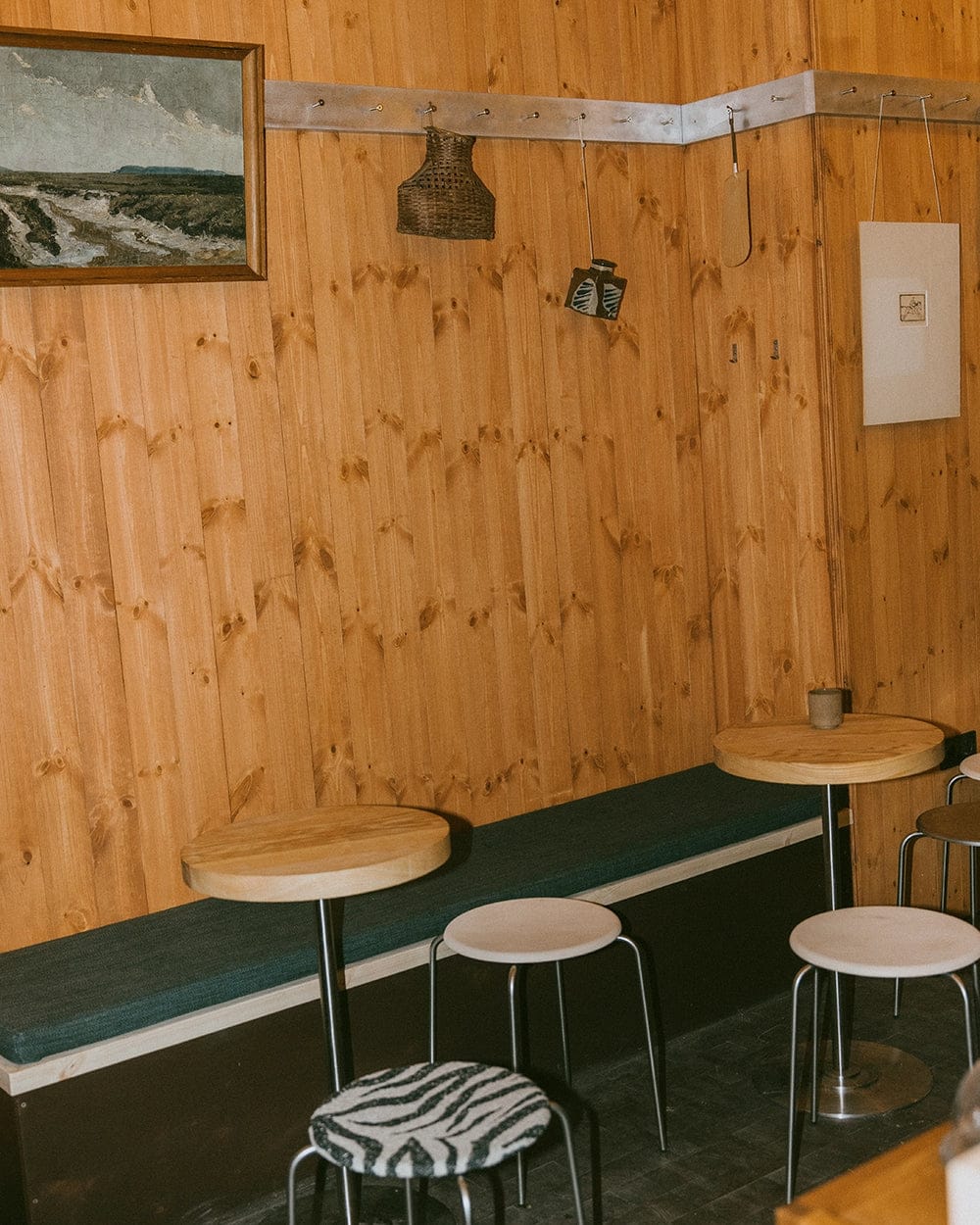 Pine walls, a bench and round tables with stools in Cabin