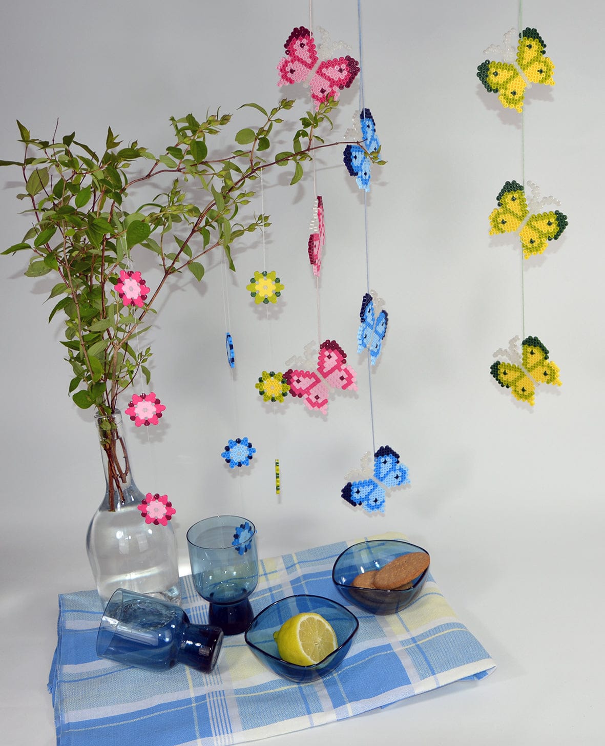 Butterflies and flowers ironed from Hama Midi beads, hung as a mobile