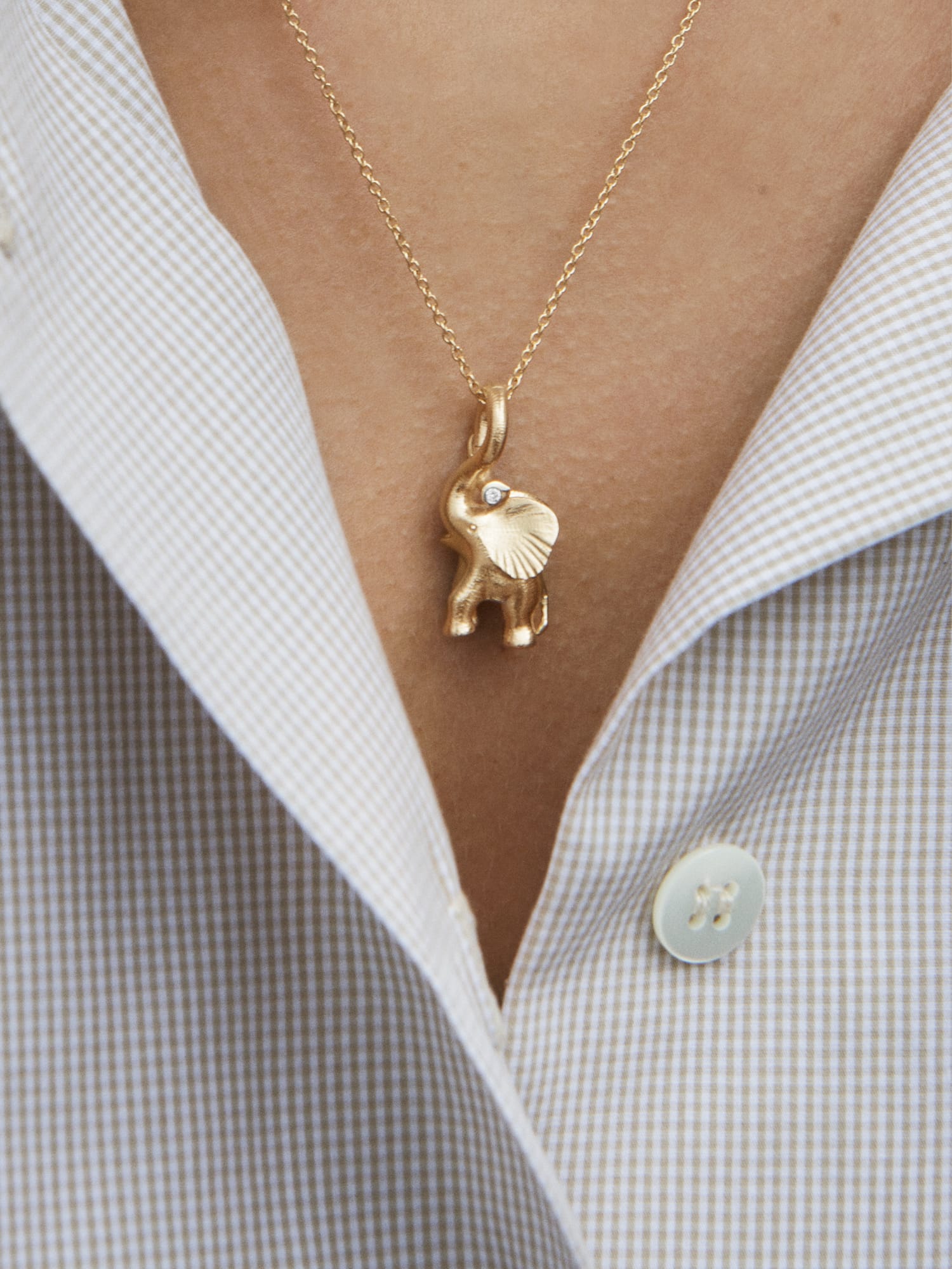 Gold elephant pendant with a diamond eye, on a chain