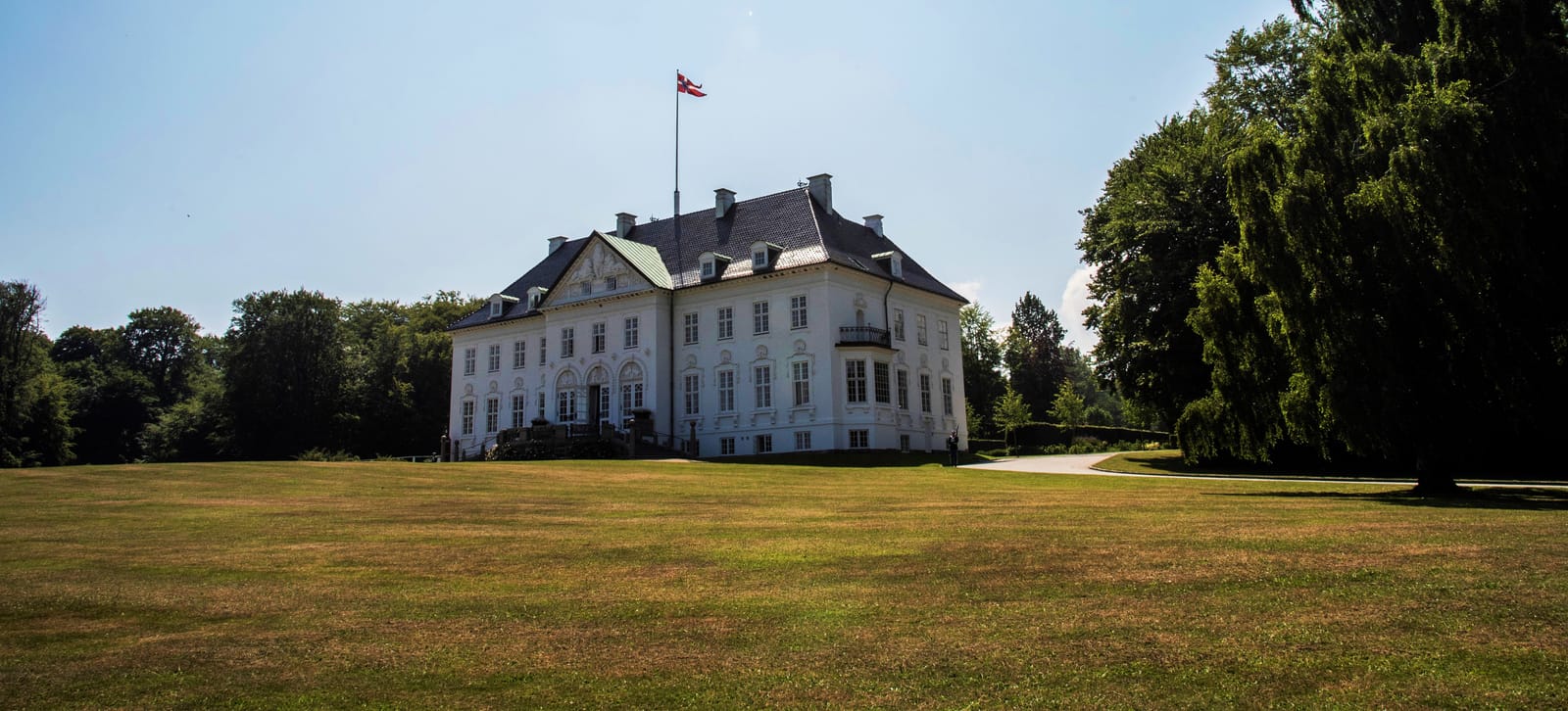 The white palace across the lawn, the flag raised