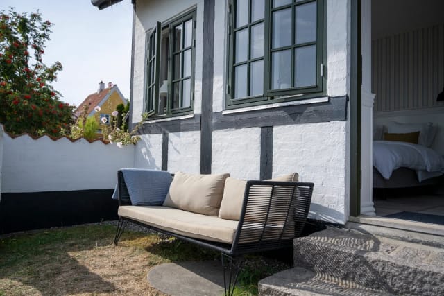 The whitewashed half-timbered house, with a room open to the garden