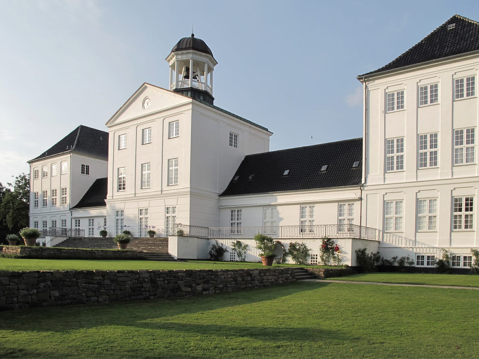 The white palace and its bell tower seen from the lawns