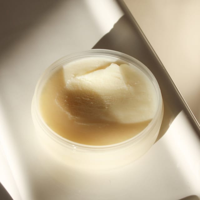 An open jar of CALM balm in the sun