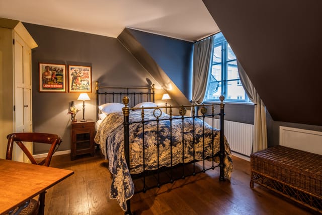 A room under the roof with a brass bed