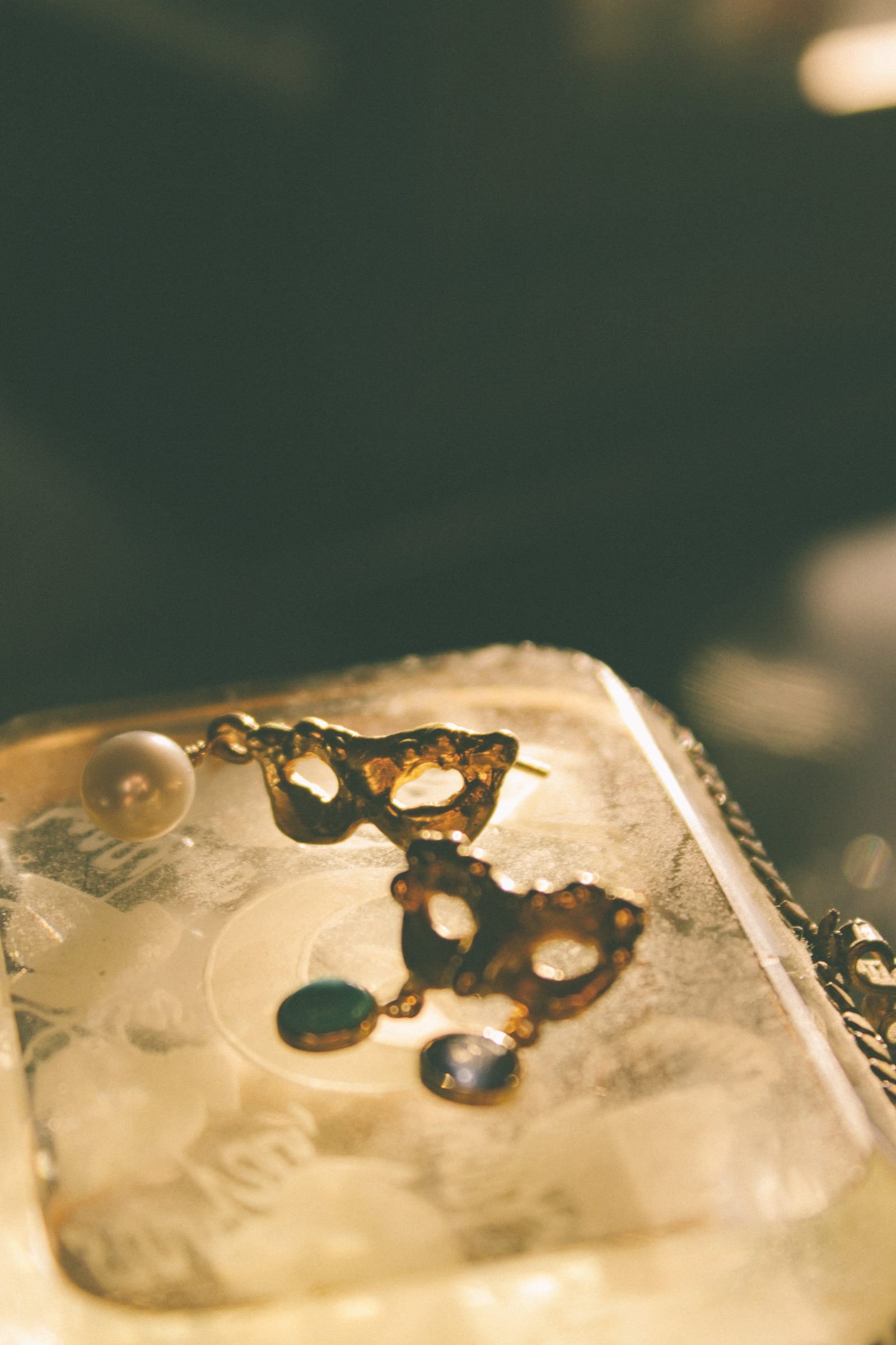 Gold mask earrings with a pearl and coloured stones