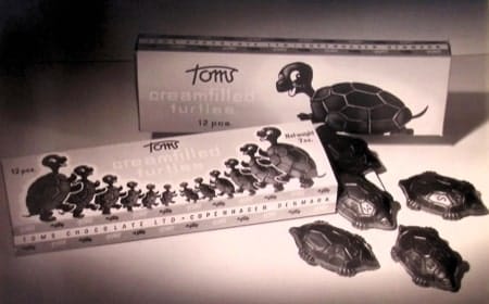 Vintage boxes of Toms creamfilled chocolate turtles shown beside the chocolates themselves.