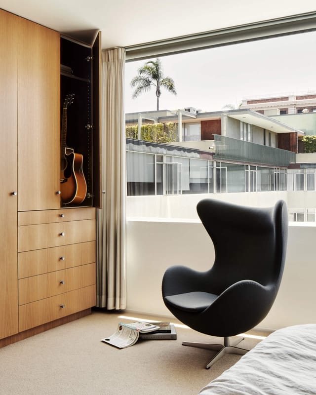 An Egg chair in grey fabric by a window
