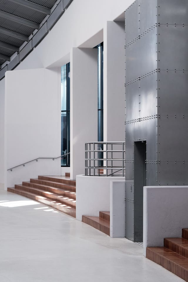 Stairs and a riveted steel wall inside the Axis