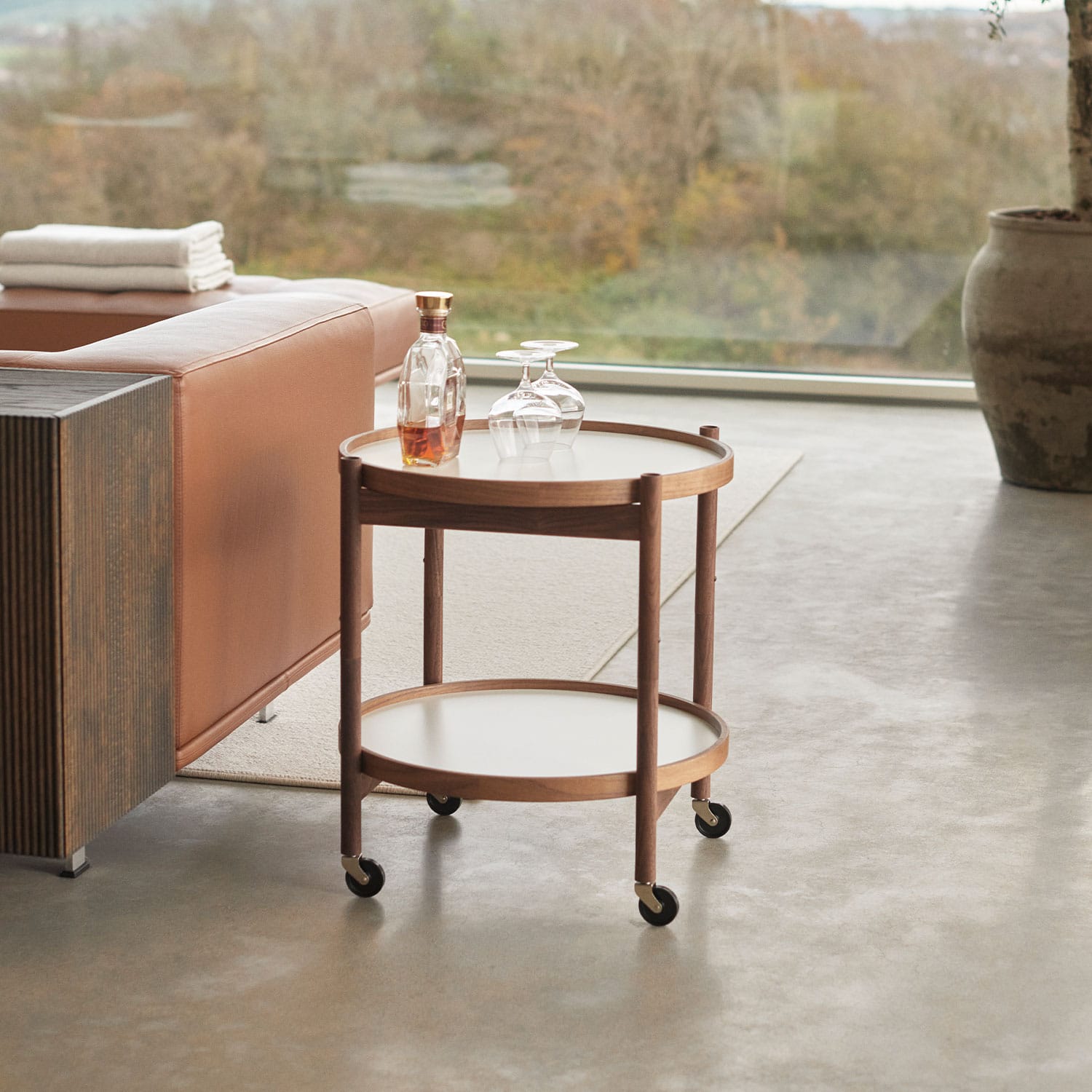 The Bølling Tray Table beside a leather sofa