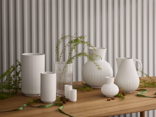 White Lyngby vases on a wooden table with other fluted pieces