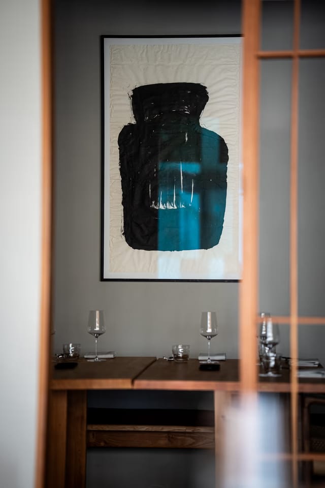 A table laid with glasses beneath a painting