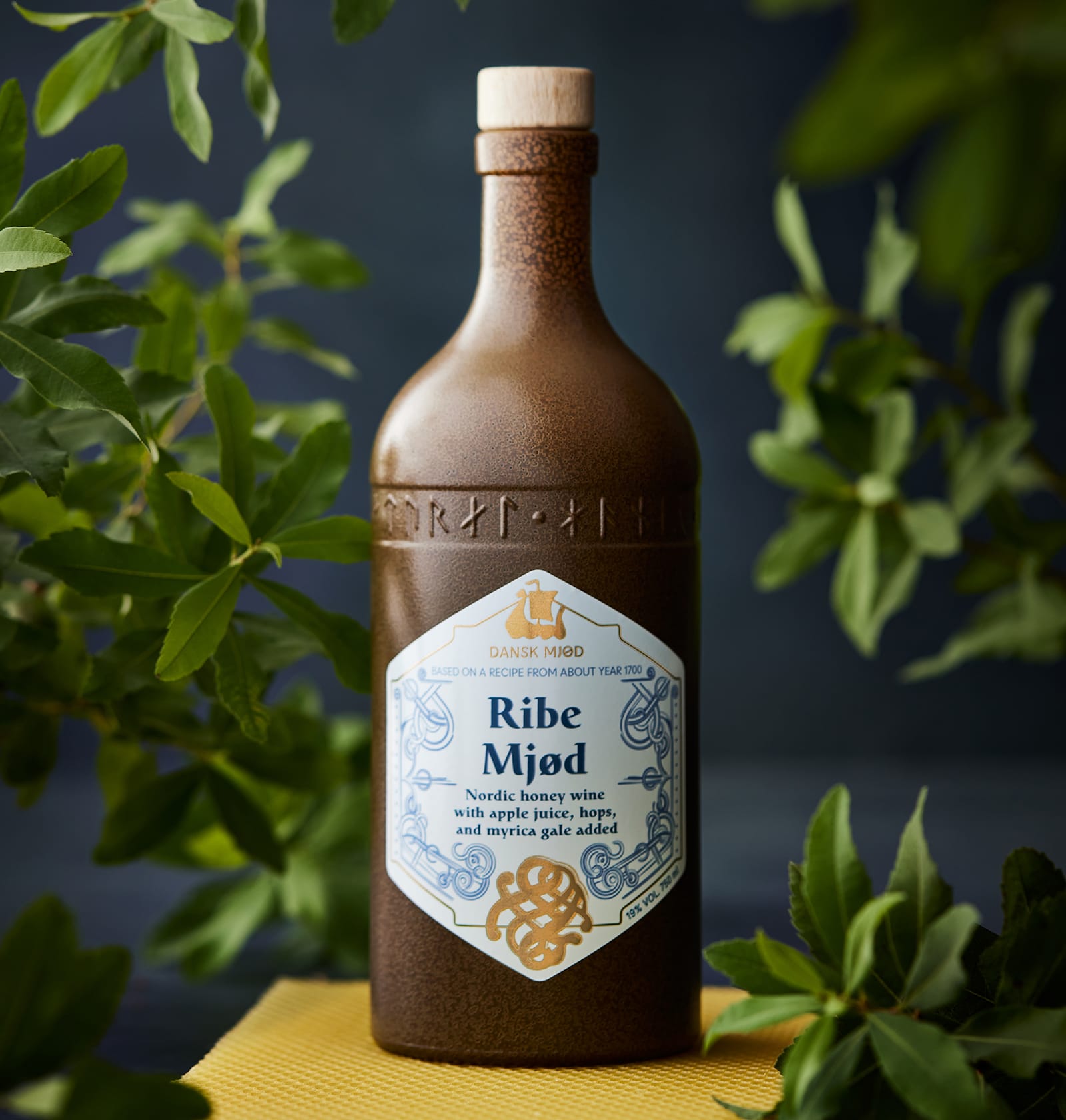 A stoneware bottle of Ribe Mjød among leaves