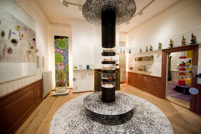 A gallery with microscopes and a central display column