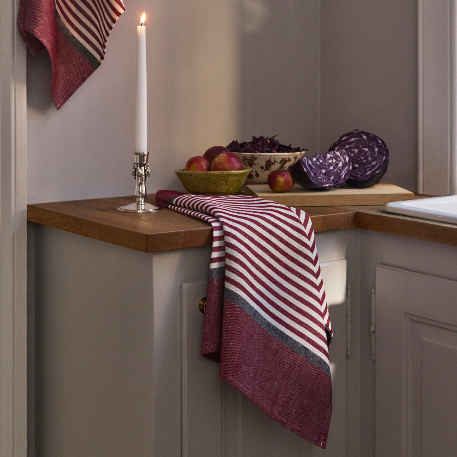 Abild tea towel in carmine red on a kitchen counter