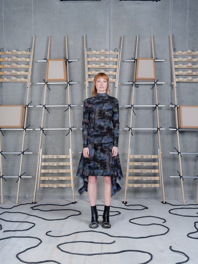 A printed top and handkerchief skirt against a wall of wooden ladders