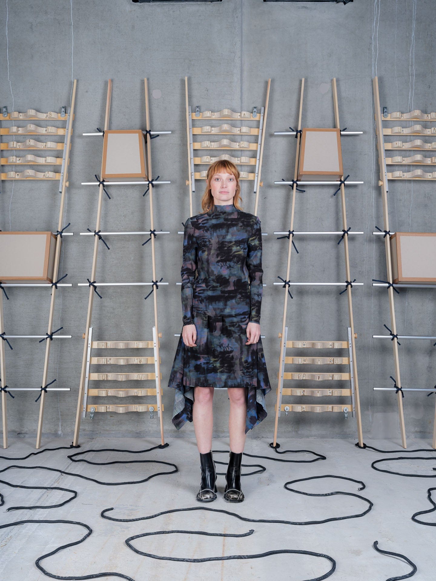 A printed top and handkerchief skirt against a wall of wooden ladders