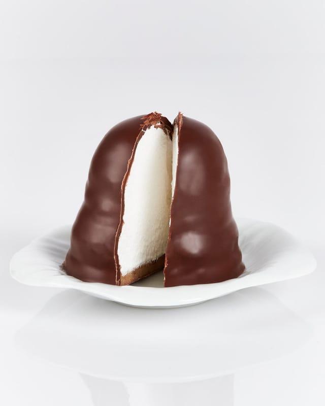 A Grand Cru flødebolle cut open: marzipan base, vanilla foam, dark chocolate