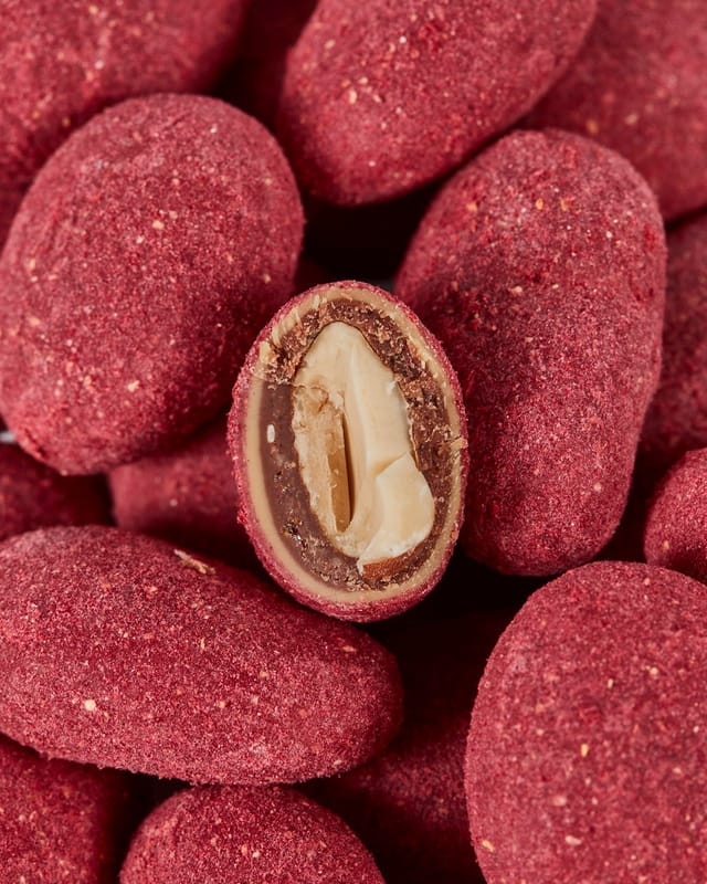 Raspberry Red almonds cut open, showing the chocolate and almond layers