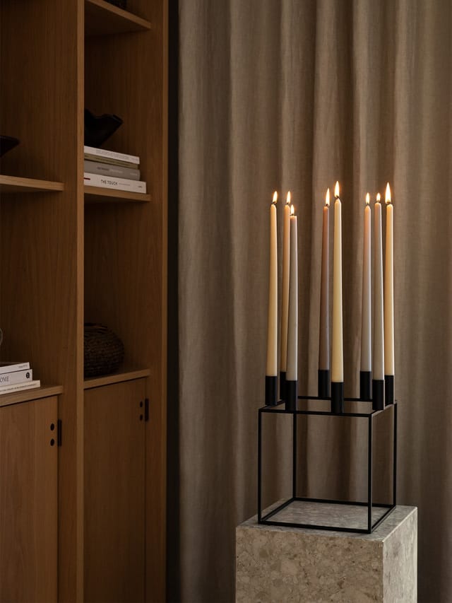 A Kubus 8 with lit candles on a stone plinth