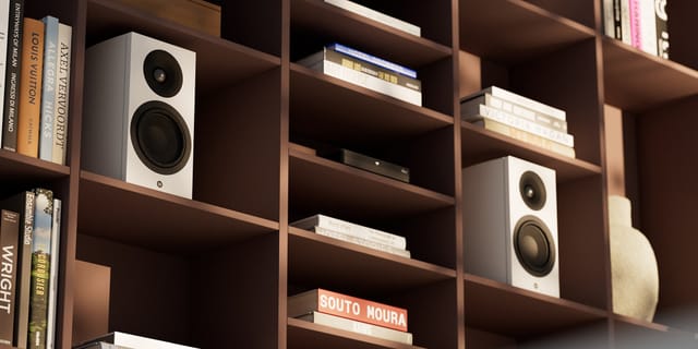 A pair of Legend 5.2 Silverback DS speakers in white on a bookshelf