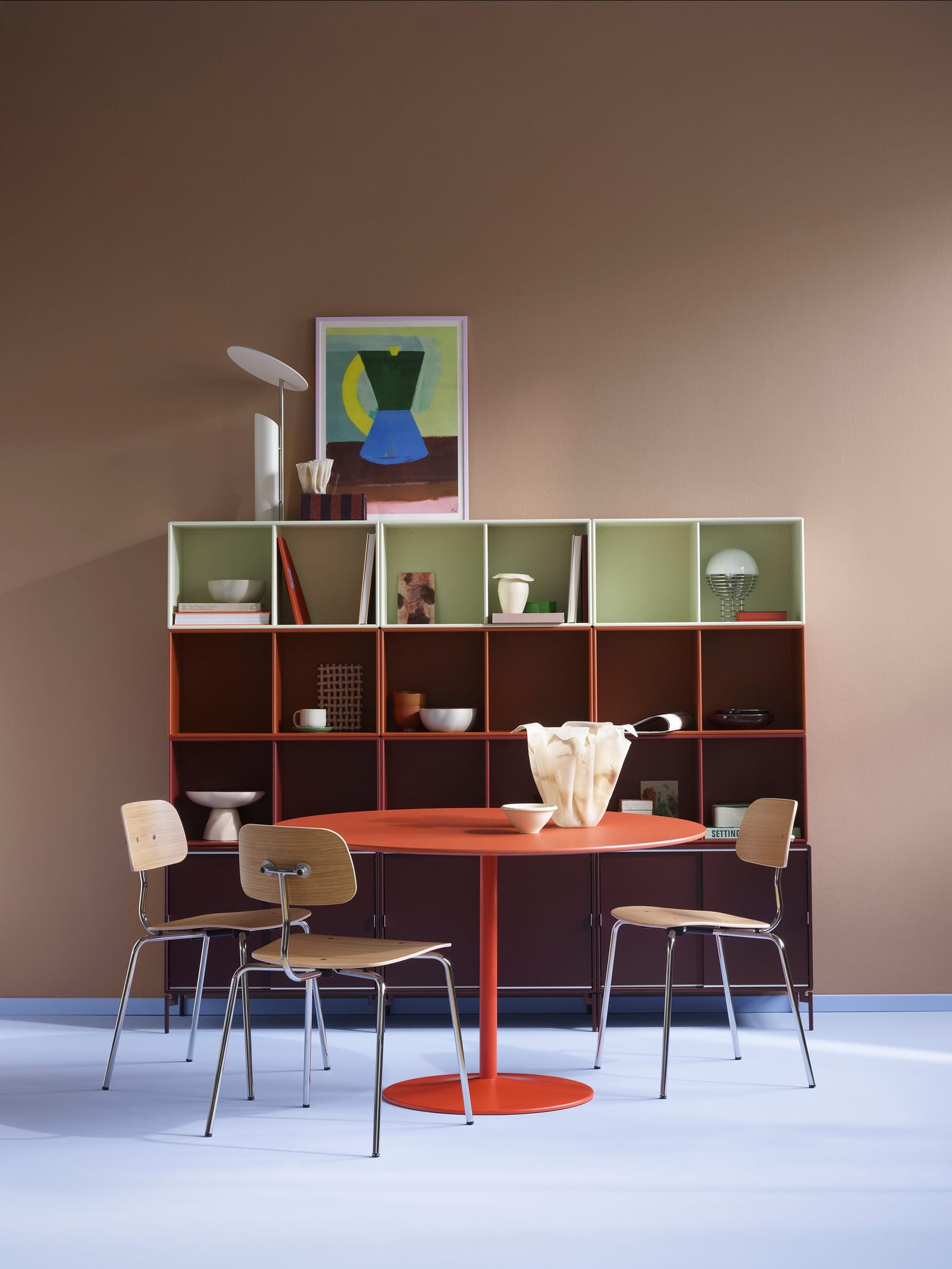 A wall of Montana System modules in three colours behind a dining table