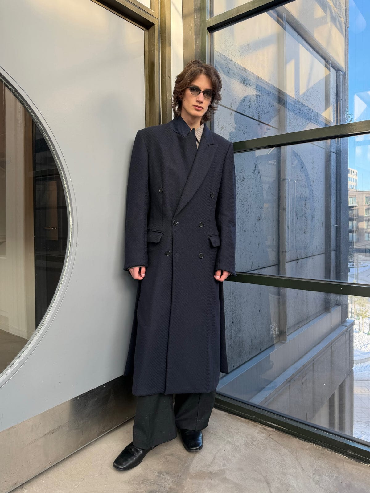 SS26 look: a navy double-breasted wool coat worn over wide trousers