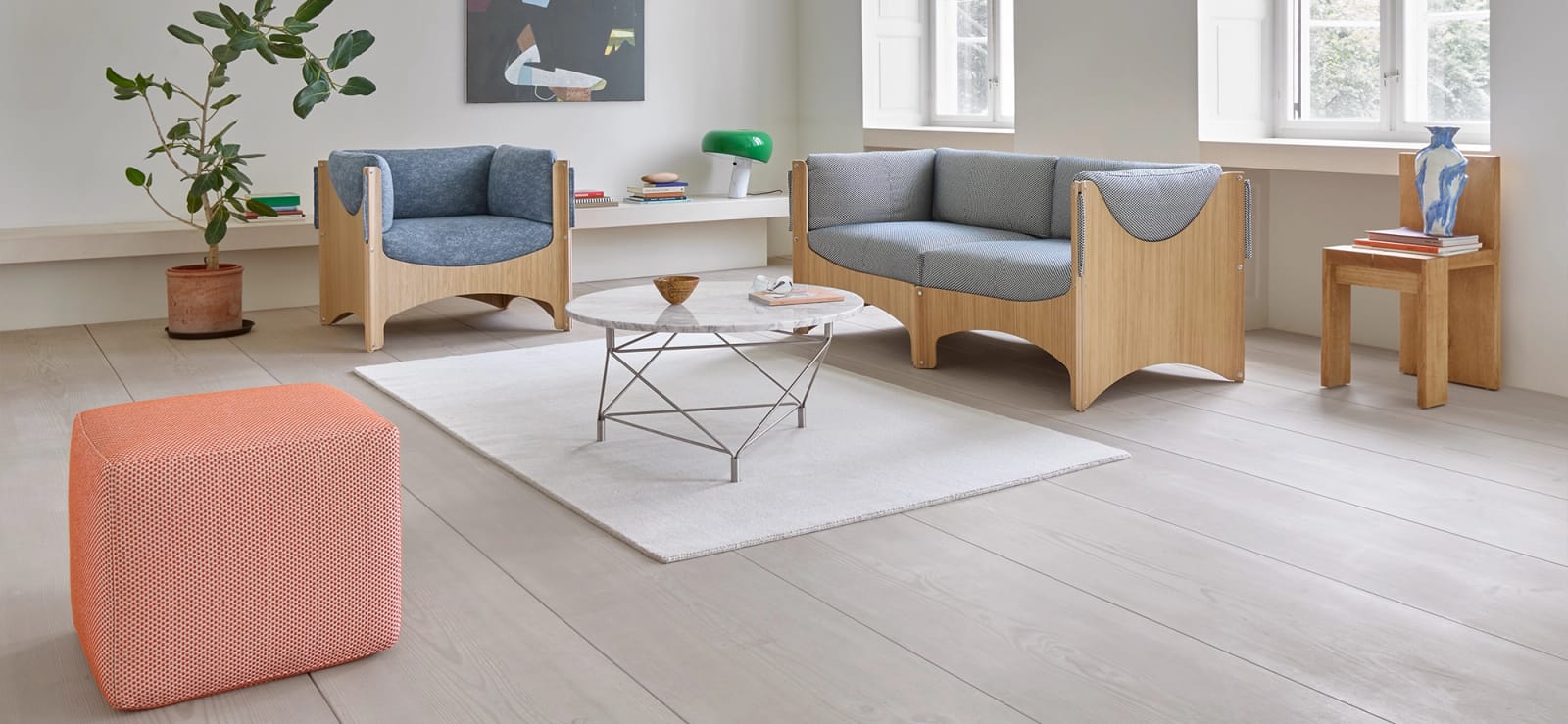 Bug chair in blue and Bug two-seater in grey, with an orange footstool
