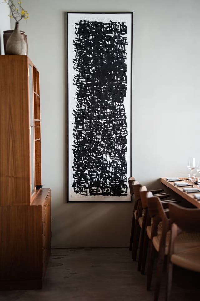 Tables along the wall under a large ink painting