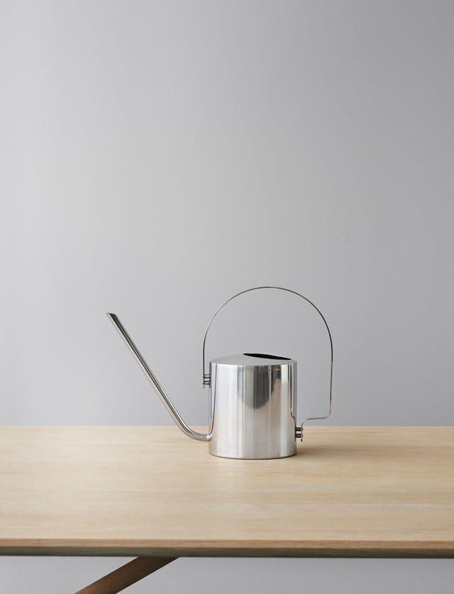 The steel watering can on an oak table