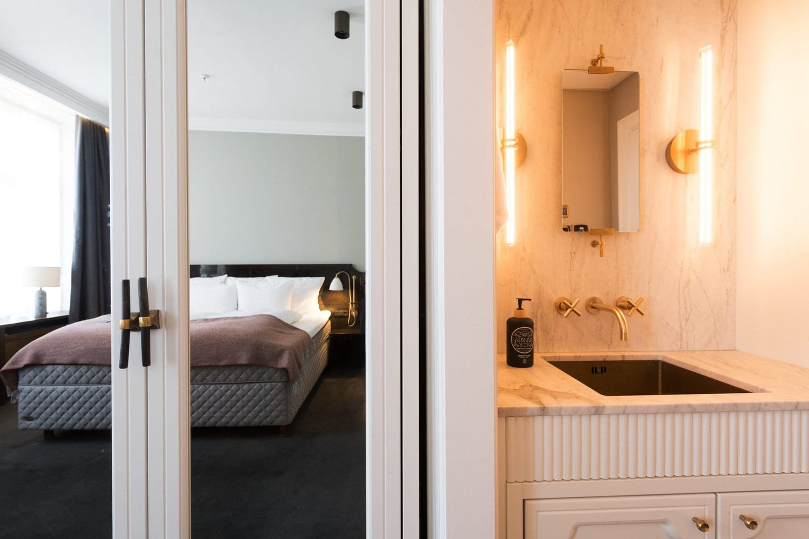 A Large Deluxe room seen past its marble washbasin