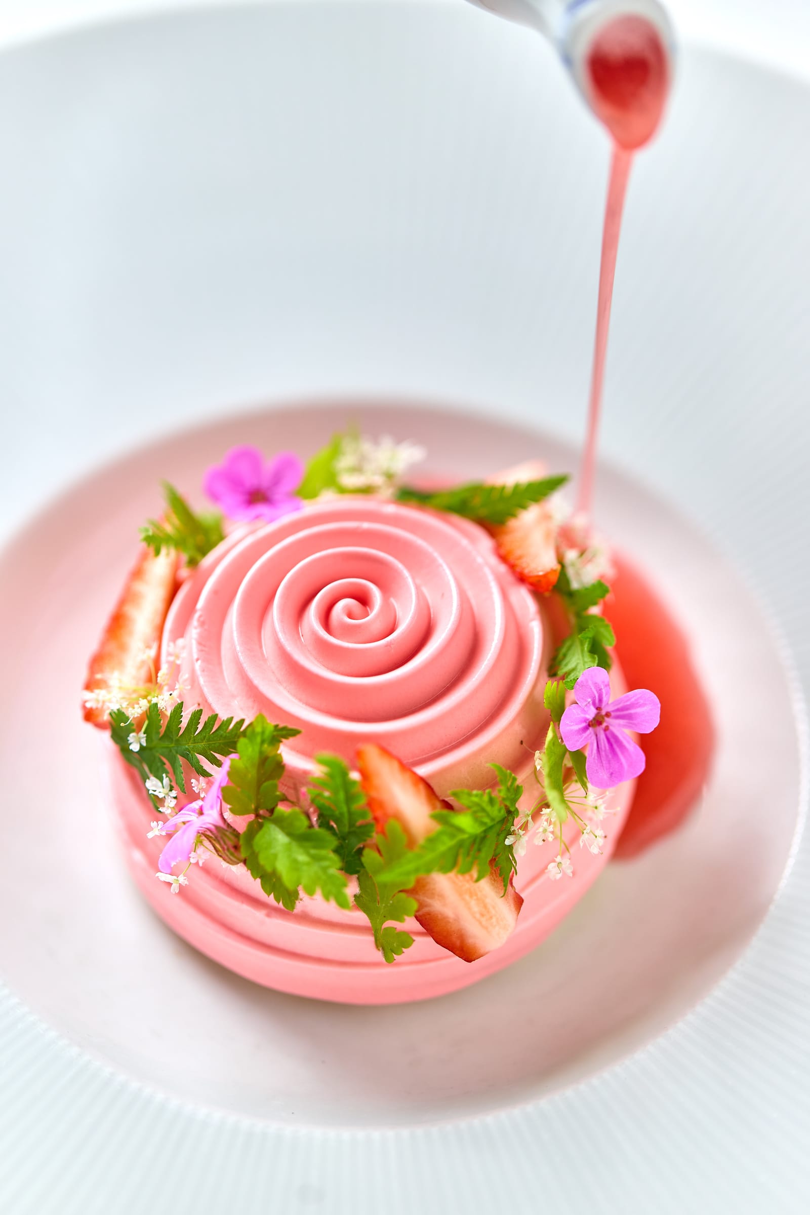 A plated strawberry dessert with edible flowers