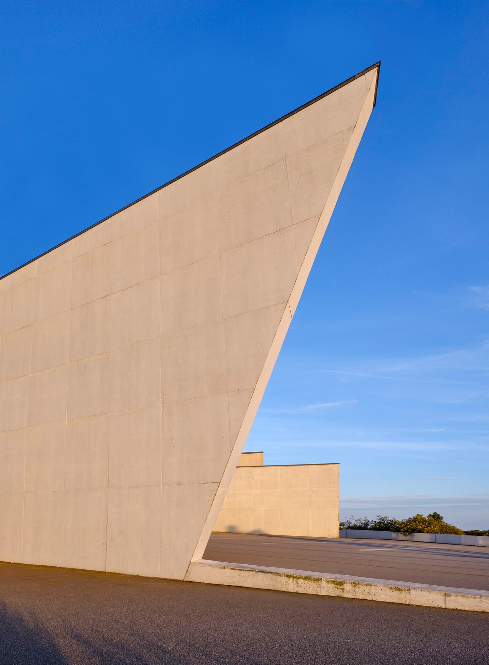 The prow-like concrete wall of the museum in evening sun