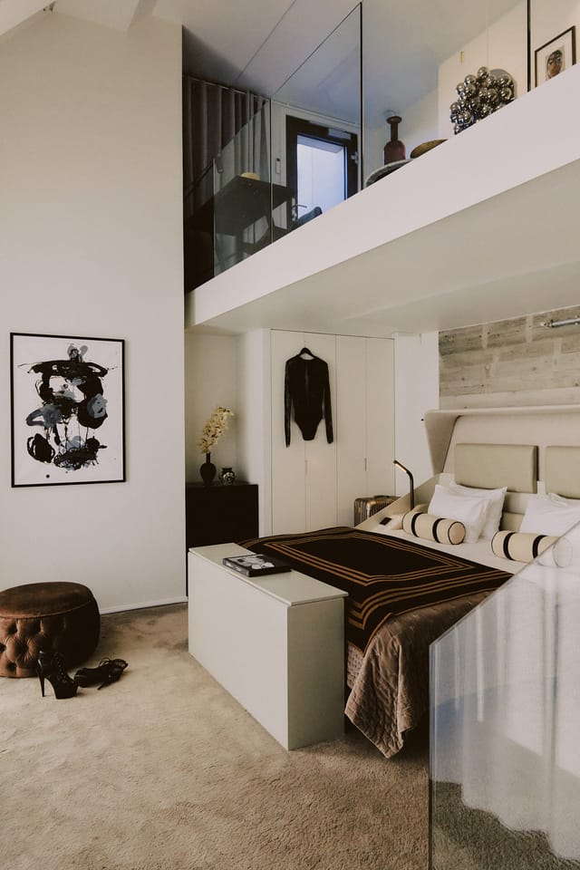 A room with a gallery level above the bed