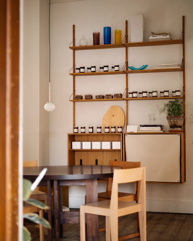 A dining table and shelves of preserves in the eatery