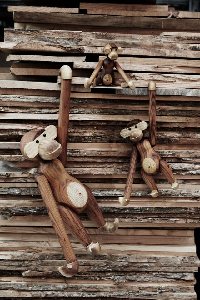 Three Monkeys hanging from a stack of planks