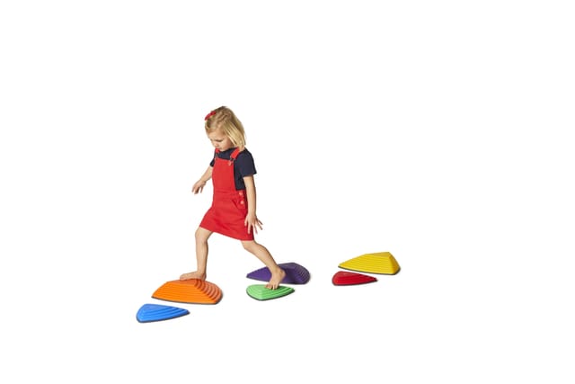 A child stepping across a path of River Stones