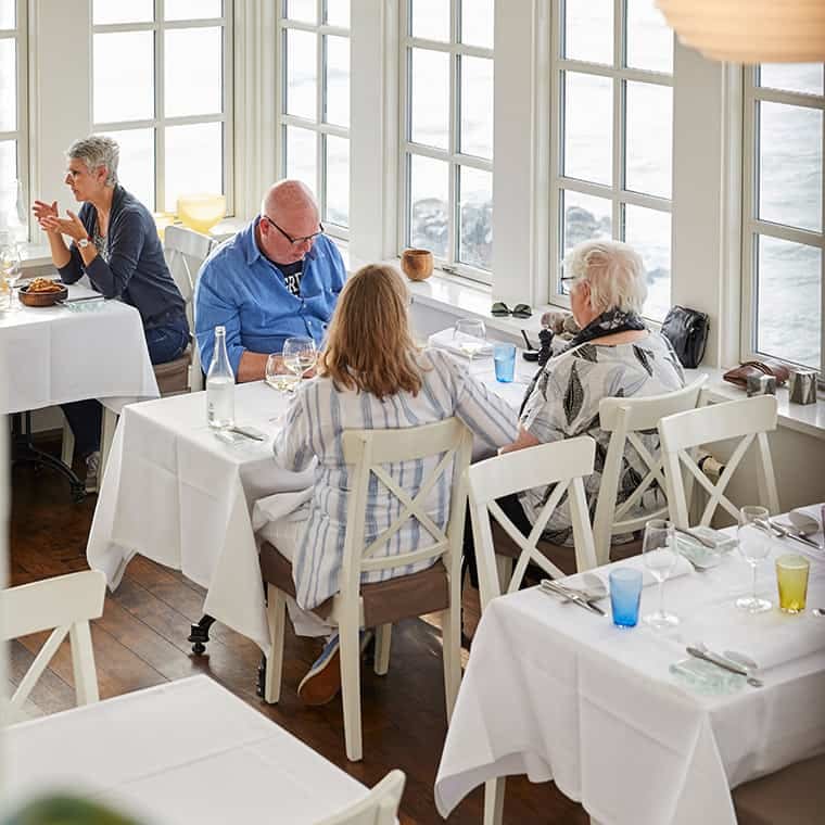 Guests at tables by the sea windows