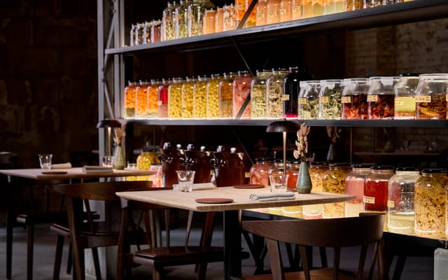 Tables before shelves of preserves