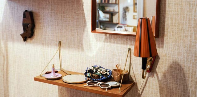 A shelf, mirror and wall lamp in the 1950s flat