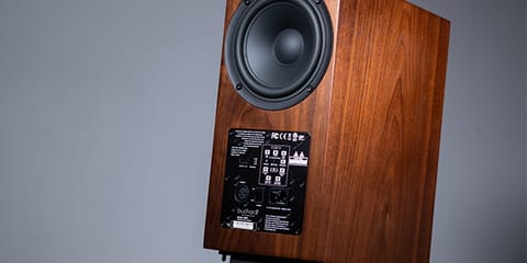 An A500 in walnut, showing its rear woofer and amplifier panel