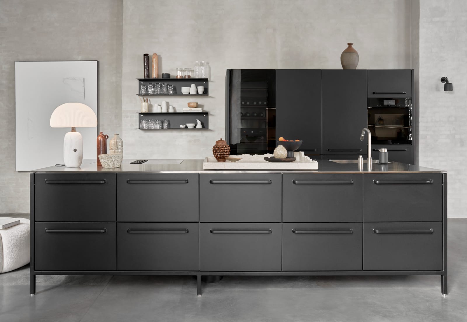 A black V1 kitchen island with tall modules behind