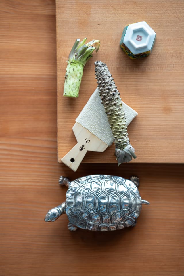 Fresh wasabi and a grater on a wooden counter