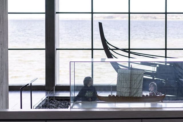 A Viking ship and a model in the hall facing Roskilde Fjord