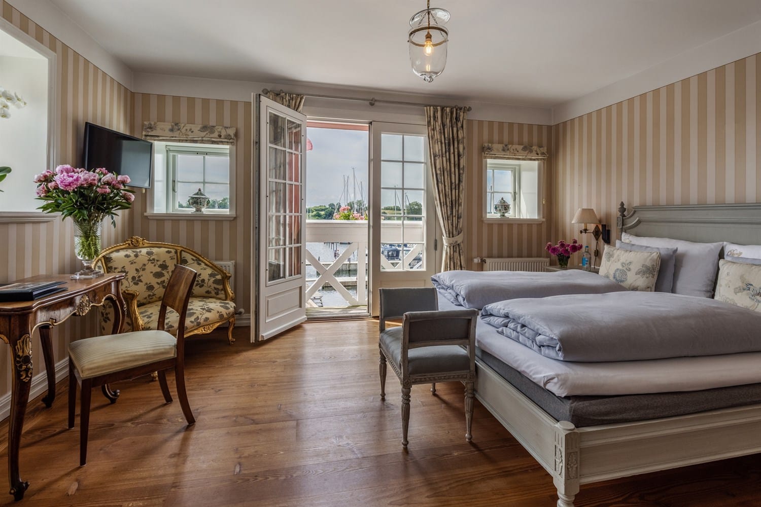 A room with a balcony over the harbour