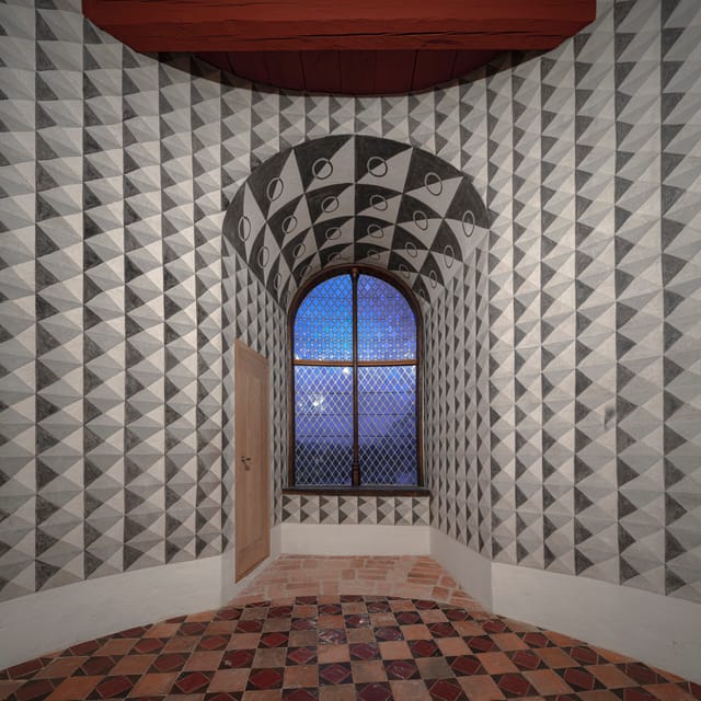 A restored room with black and white geometric wall painting and a tiled floor